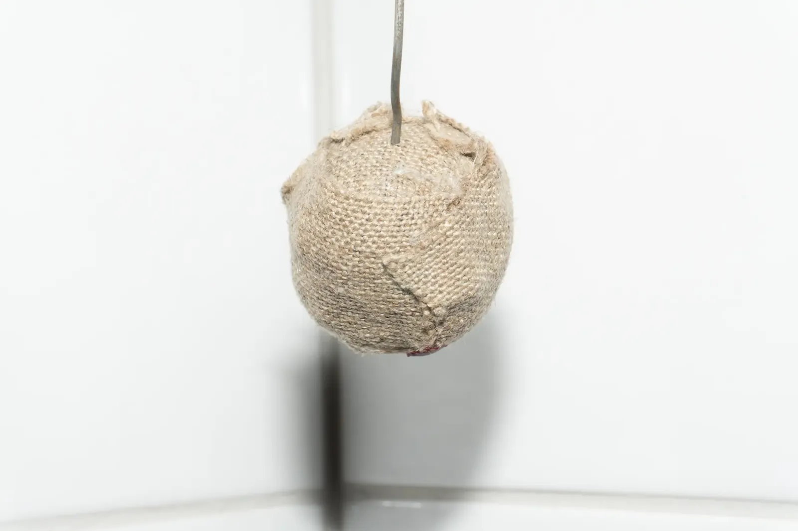 The same object photographed from a second angle against a white wall.